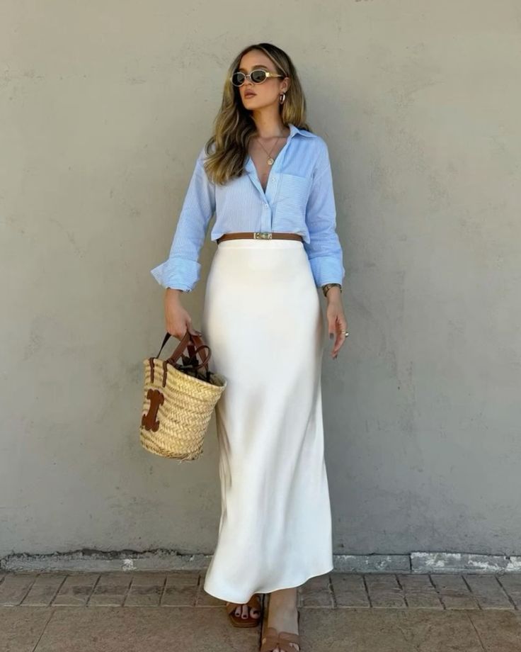 Light blue button-up shirt tucked into a white silk midi skirt